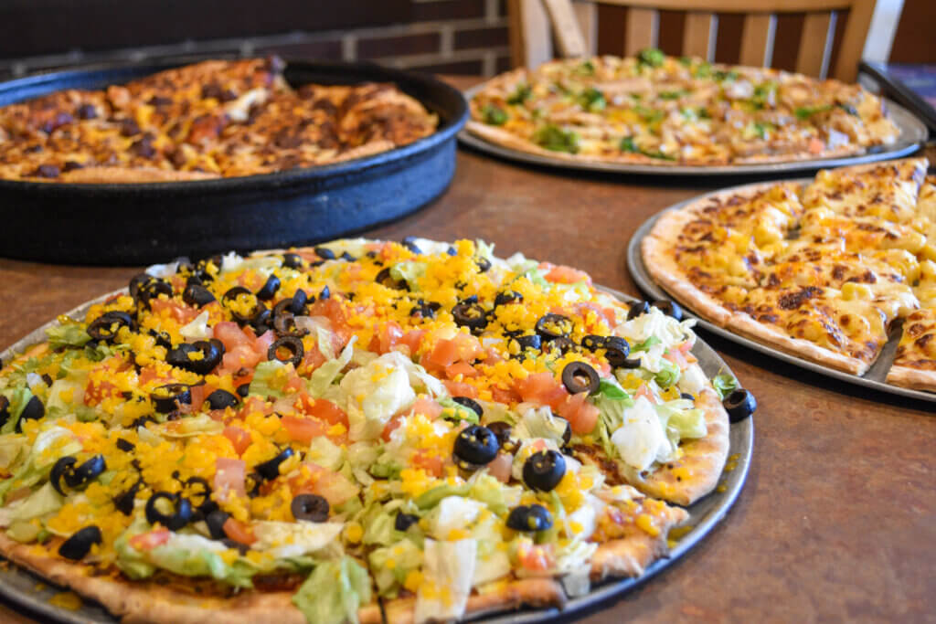 Taco Pizza with 3 other pizzas in the background