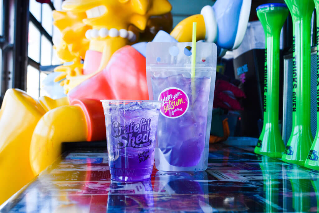 Purple cocktail in a glass and a drink pouch