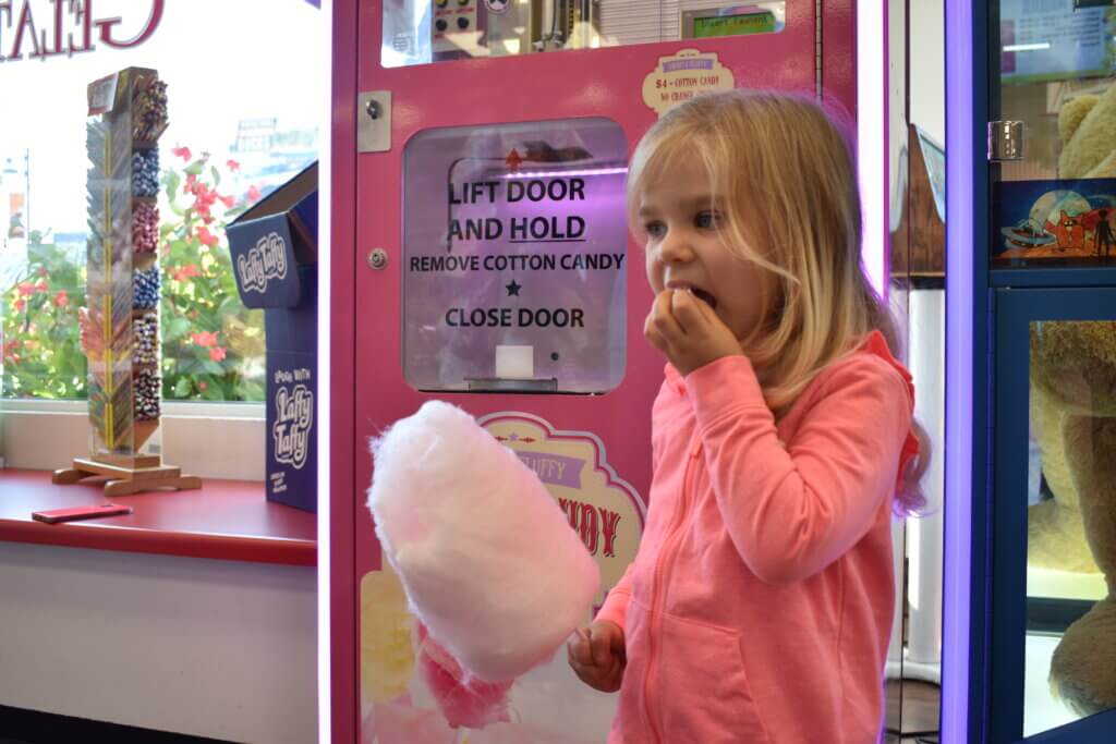 Young girl eating cotton candy at Goody Goody Gumdrop