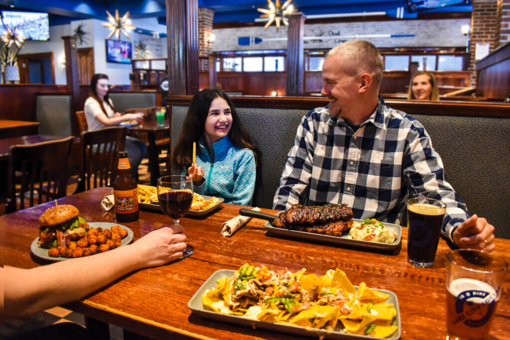 Father and daughter sitting together in a at Lake City Social dining with their family