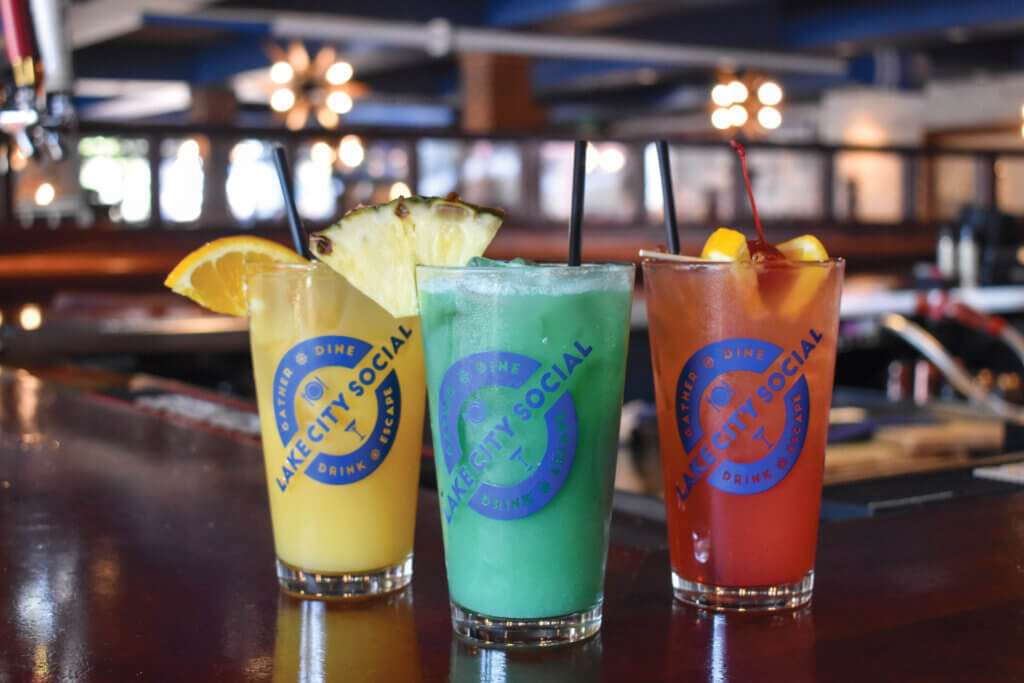 Three bright colored cocktails sitting on the bar