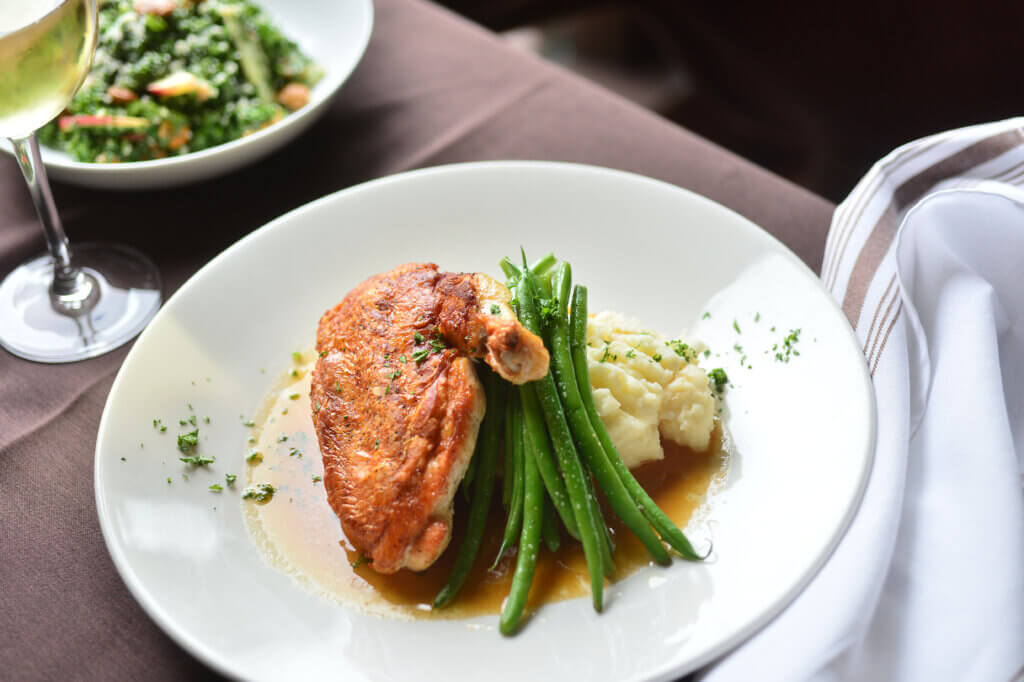 Plate of chicken leg, green beans, and mashed potatoes